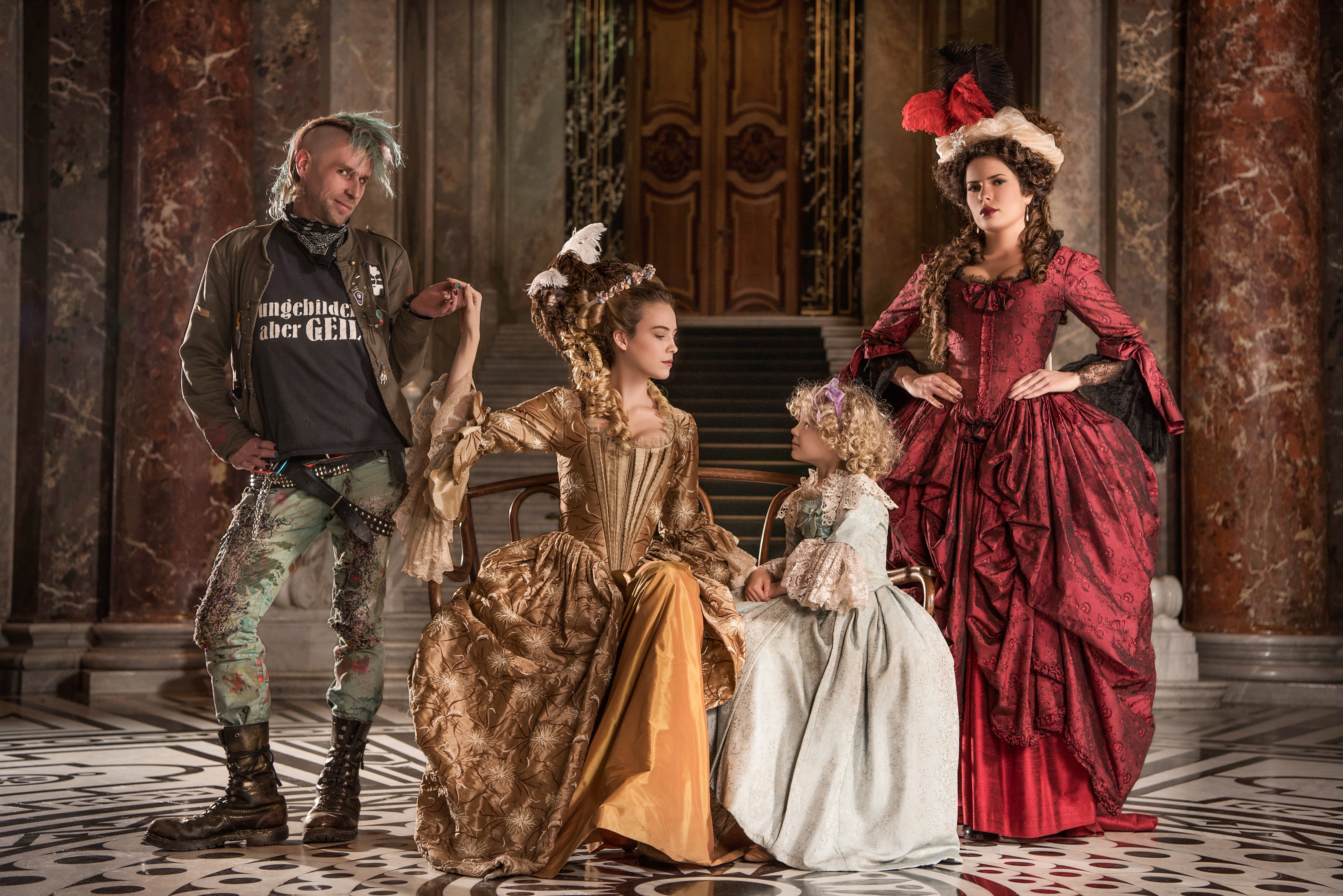 vivienne westwood inspired advertising photo shoot in khm vienna by fashion historian and stylist katalina sasdy. there are four people in the picture, two ladies, each in yellow and red rococo dresses, a little girl in a light blue rococo dress and a punk in a provocative outfit with raised green hair. the punk is holding the hand of the lady in the yellow dress who represents marie antoinette. the small girl is her daughter marie therese. the lady in red is the queens friend, madame de lamballe.