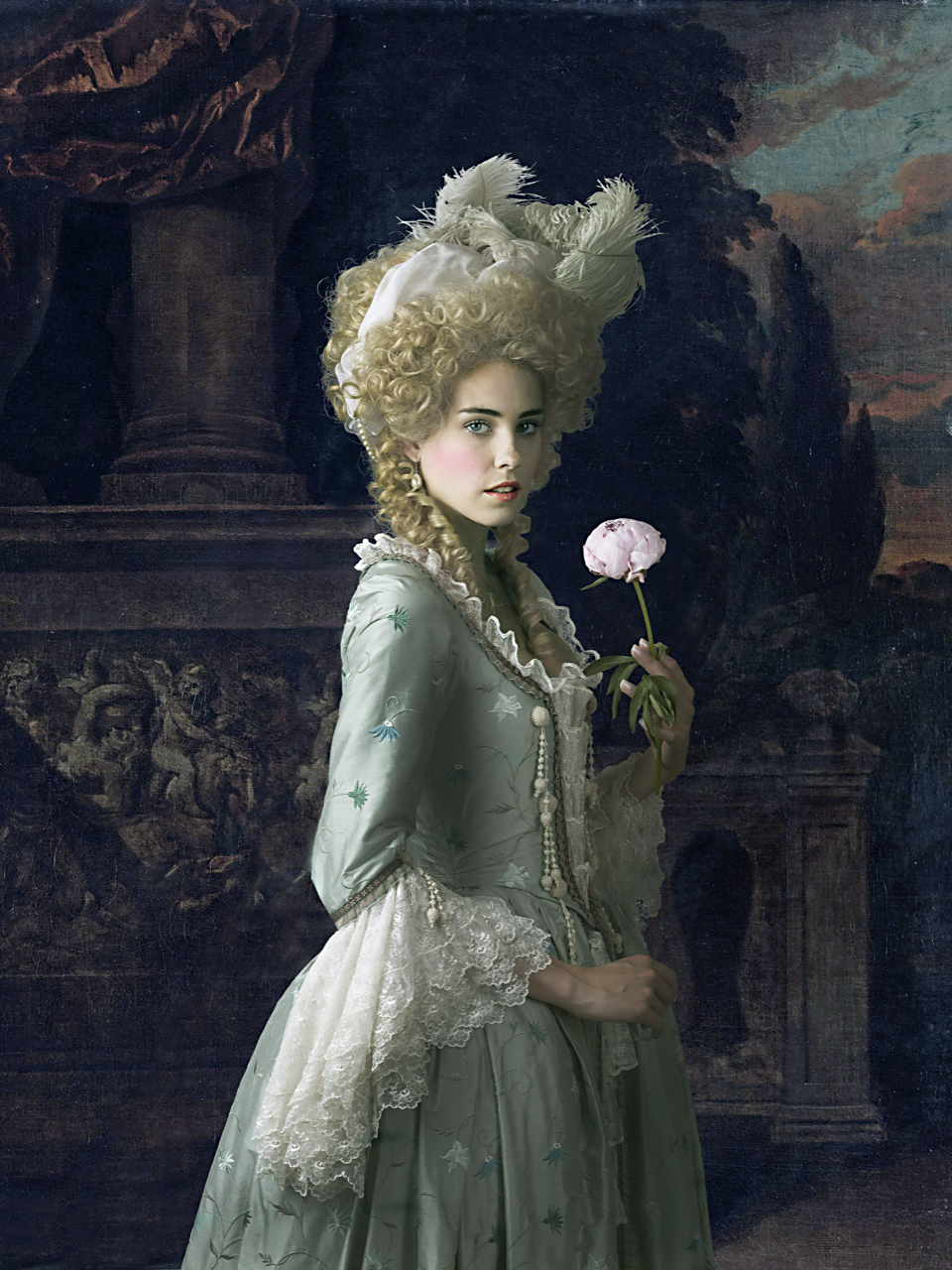 18th century fashion inspired advertising photo shoot in rijksmuseum amsterdam by fashion historian and stylist katalina sasdy. the model is standing in front of the rijksmuseums painting with a pink rose in her hands. she is wearing a light blue rococo gown produced by lambert hofer. the ruffled sleeves are made of white lace. she is wearing a blonde hedgehog wig with a scarf and feathers.