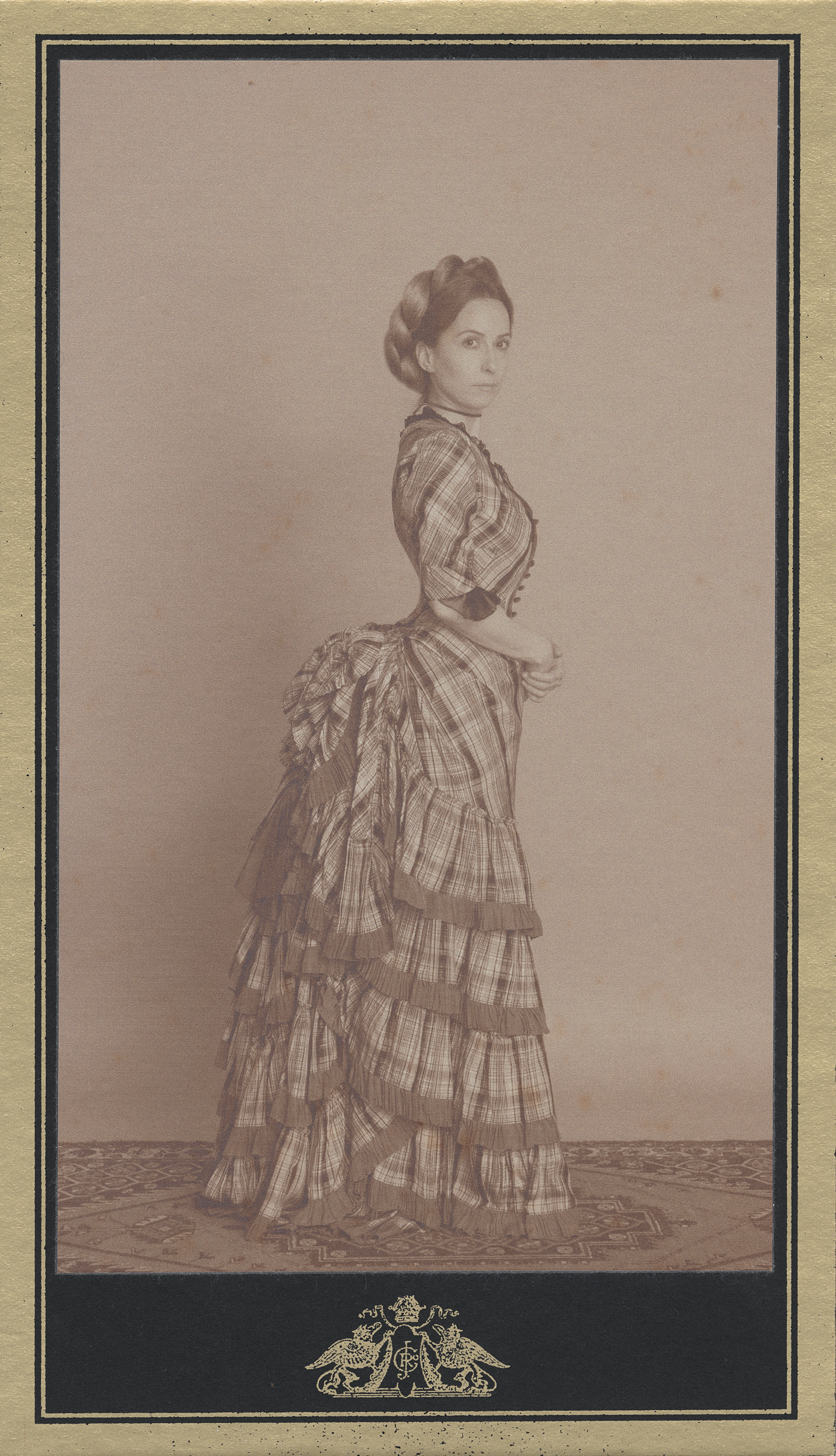 19th century fashion inspired advertising photo shoot by art director and fashion stylist katalina sasdy. a lady with blonde braided hair is wearing a checkered tournure dress full of ruffles from the 1870s. her blonde hair is braided and pinned up. the picture is in profile, so the tournure is very visible. her hands rest at her waist.